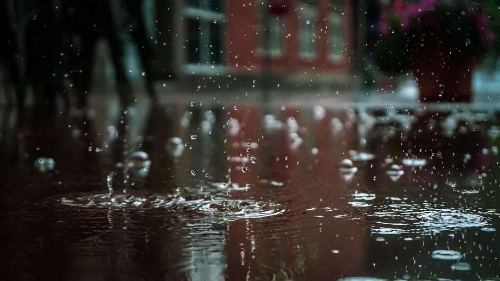 Flooding background image of rain dripping onto a puddle of water